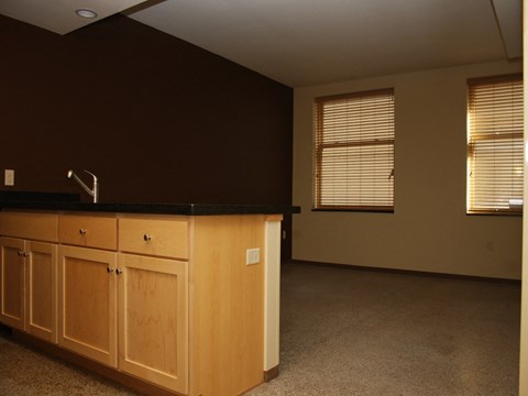 an empty kitchen with wooden cabinets and a sink