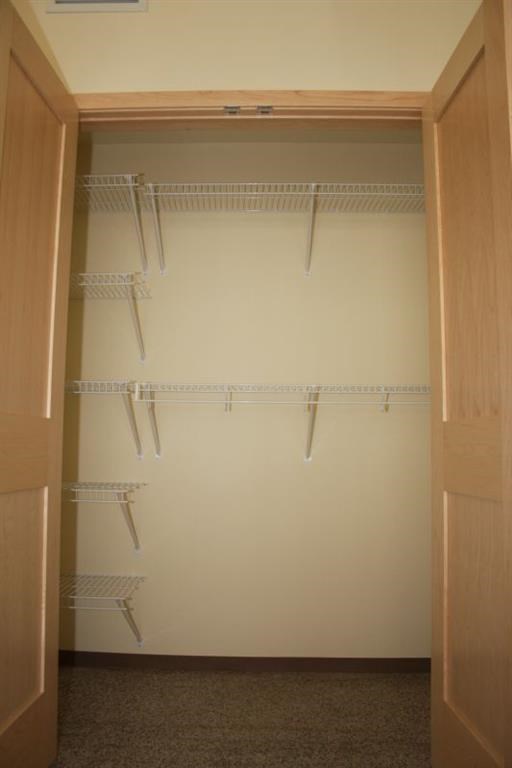 a walk in closet with shelves and hooks