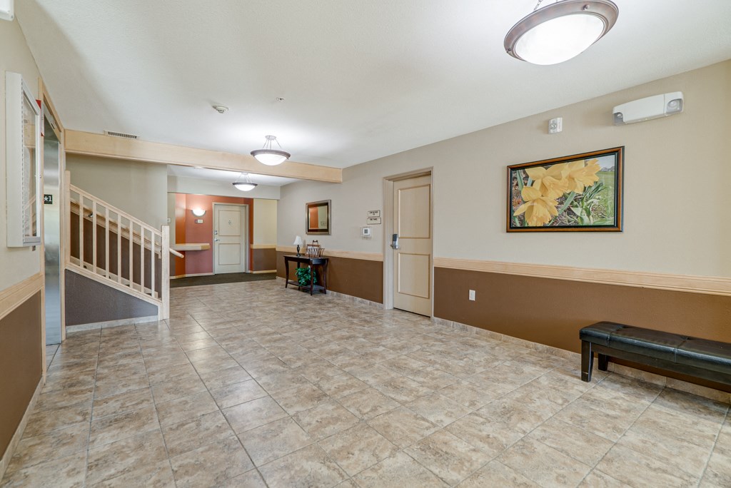 the lobby of a house with a staircase and a hall with a bench