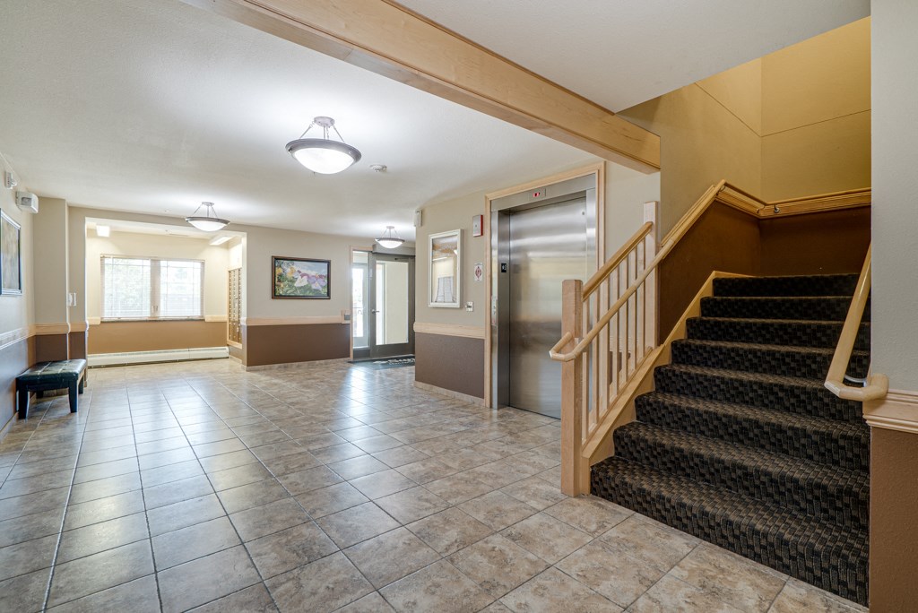 the lobby of a house with a staircase and a door