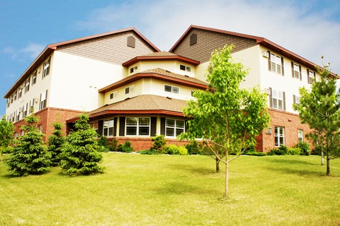 A large, multi-story building with a red brick exterior and a white trim.