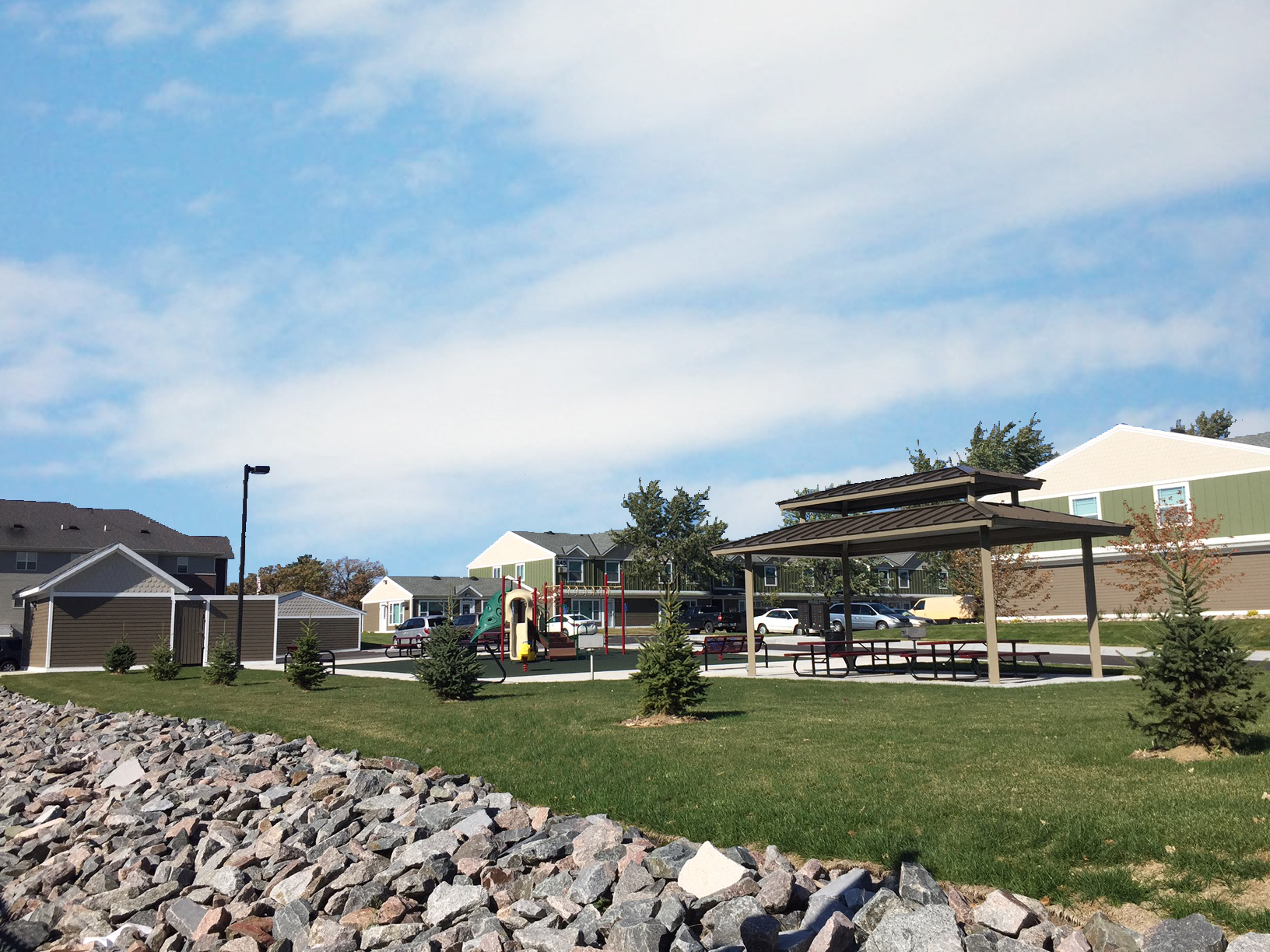 a park with a pavilion and rocks in the grass