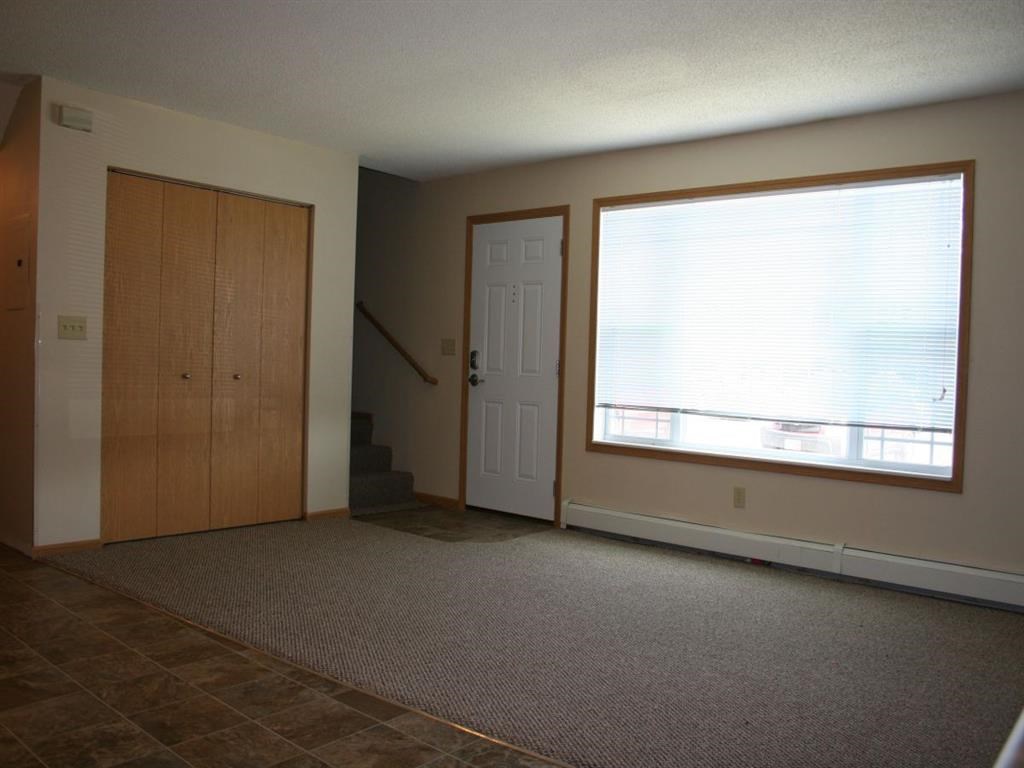 an empty living room with a large window and a door