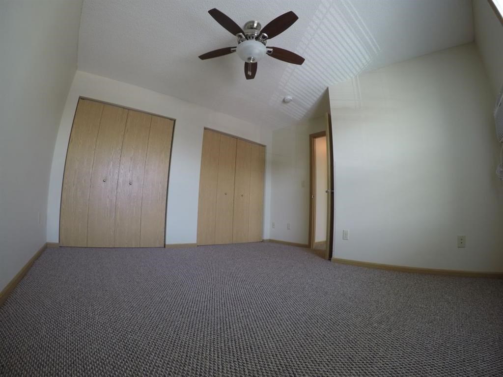 an empty living room with a ceiling fan and
