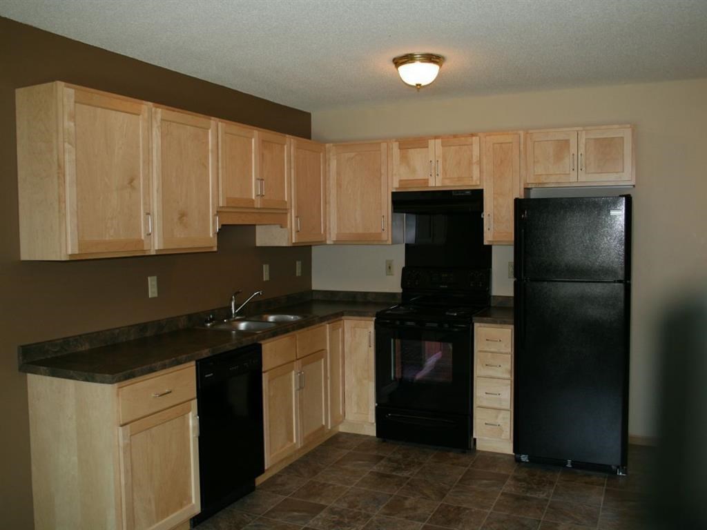 a kitchen with black appliances and wooden cabinets