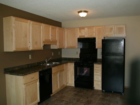 a kitchen with black appliances and wooden cabinets
