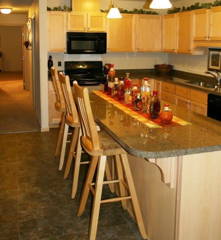 a kitchen with bar stools and a granite counter top
