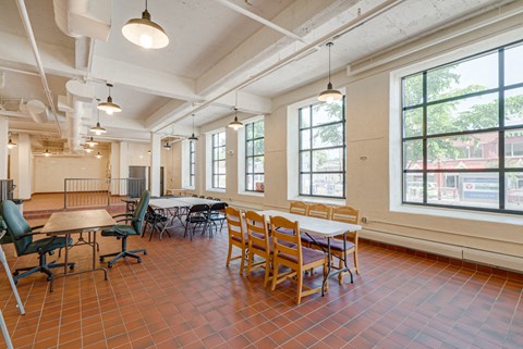 a dining room with tables and chairs in a room with large windows