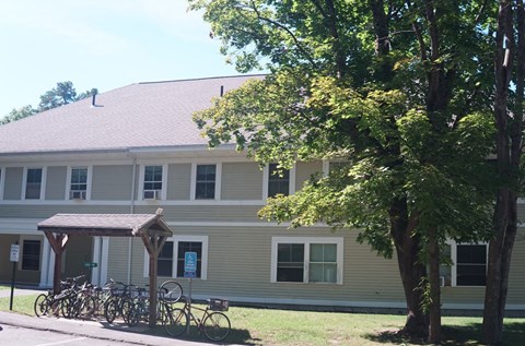 A building with a bicycle parking area in front.