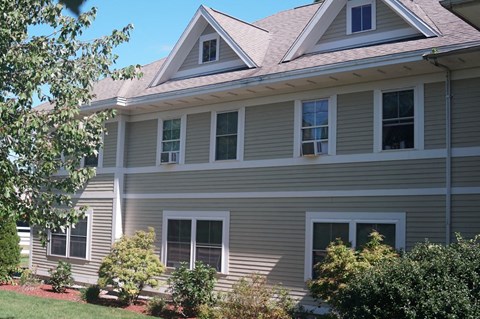 A house with a grey siding and white trim.