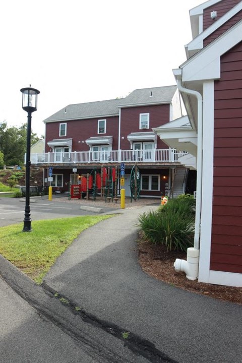 a walkway in front of a building with a porch