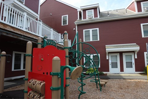 a playground in front of a red building