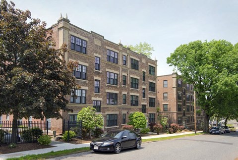 an apartment building with a car parked in front of it