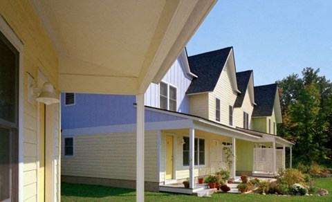 a row of houses with yellow and blue siding and a porch