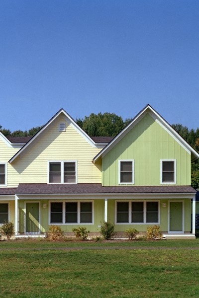 a yellow house with a green roof and a green yard