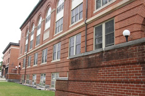 the side of a brick building with a lawn