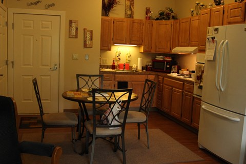 a kitchen with a table and chairs and a refrigerator