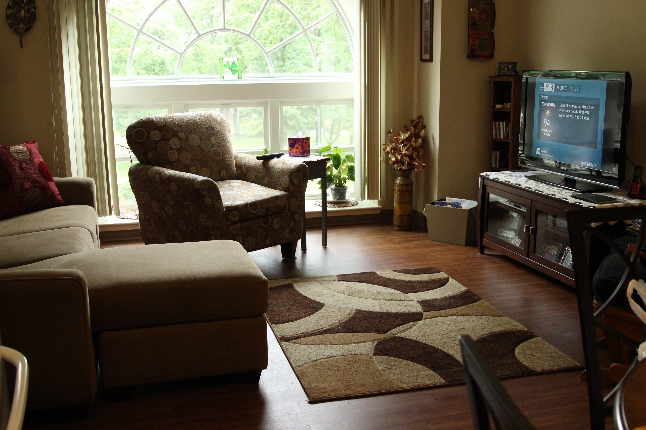 a living room with a couch and a chair and a television