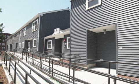 a row of rental buildings with metal railings