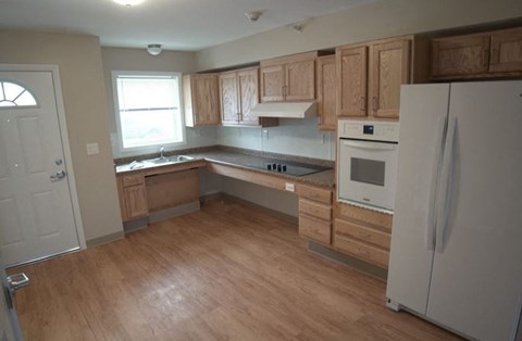 a kitchen with wooden cabinets and a white refrigerator