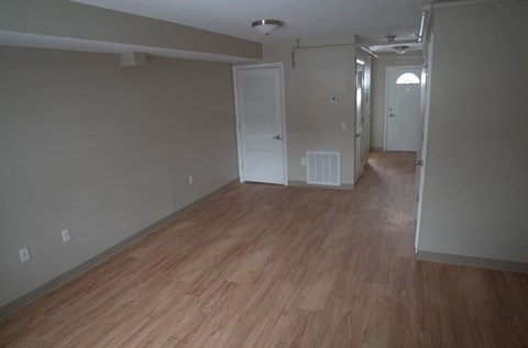 an empty living room with a wood floor
