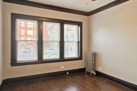 A room with a window and a radiator on the floor.