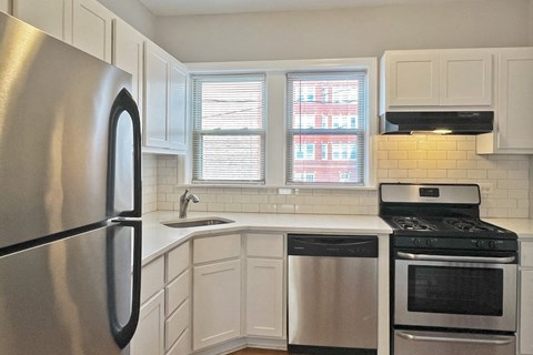 A kitchen with a stainless steel refrigerator, stove, and dishwasher.