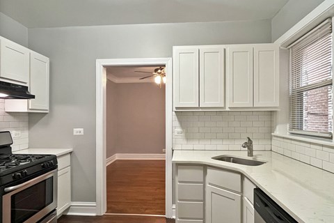 A kitchen with white cabinets and a black stove top oven.
