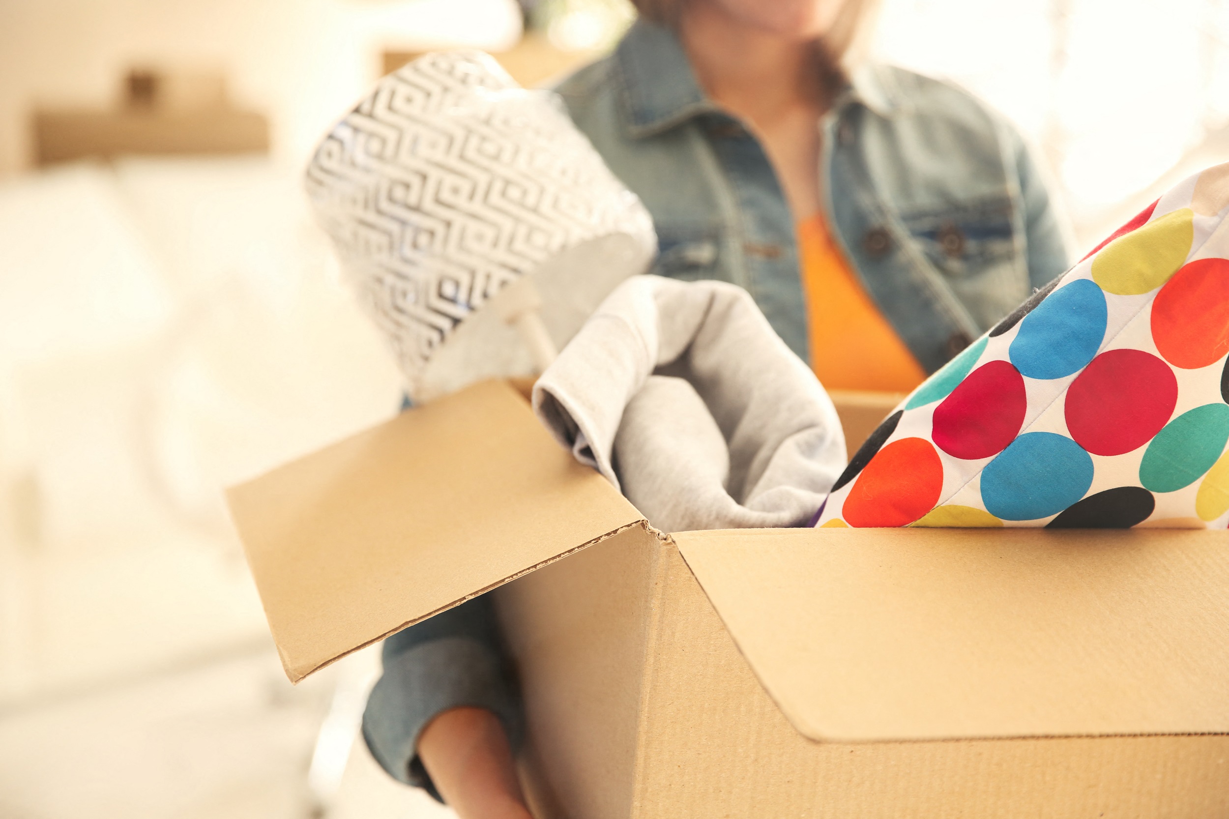 A person is unpacking a box with a gloved hand.