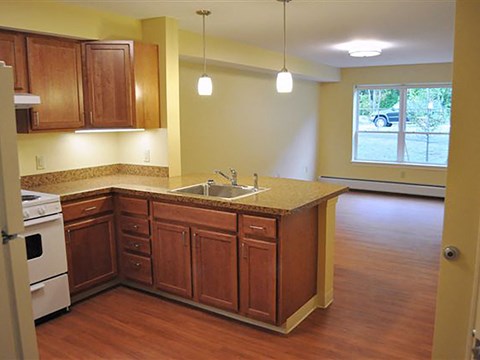 A kitchen with wooden cabinets and a white oven.