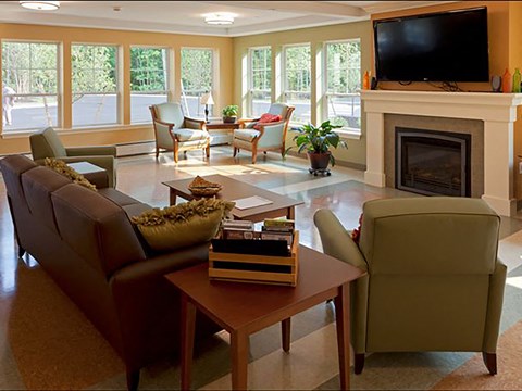A living room with a fireplace and a television on the wall.