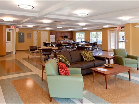 A large room with a couch, chairs, and tables.
