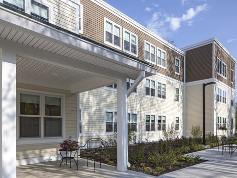 A building with a white porch and a bench in front.