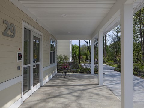 A porch with a bench and pillars.