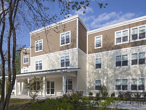A modern building with a mix of beige and brown siding.