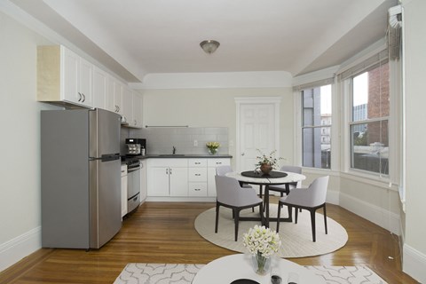 A kitchen with a table and chairs in the middle of the room.
