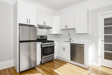 a white kitchen with stainless steel appliances and white cabinets