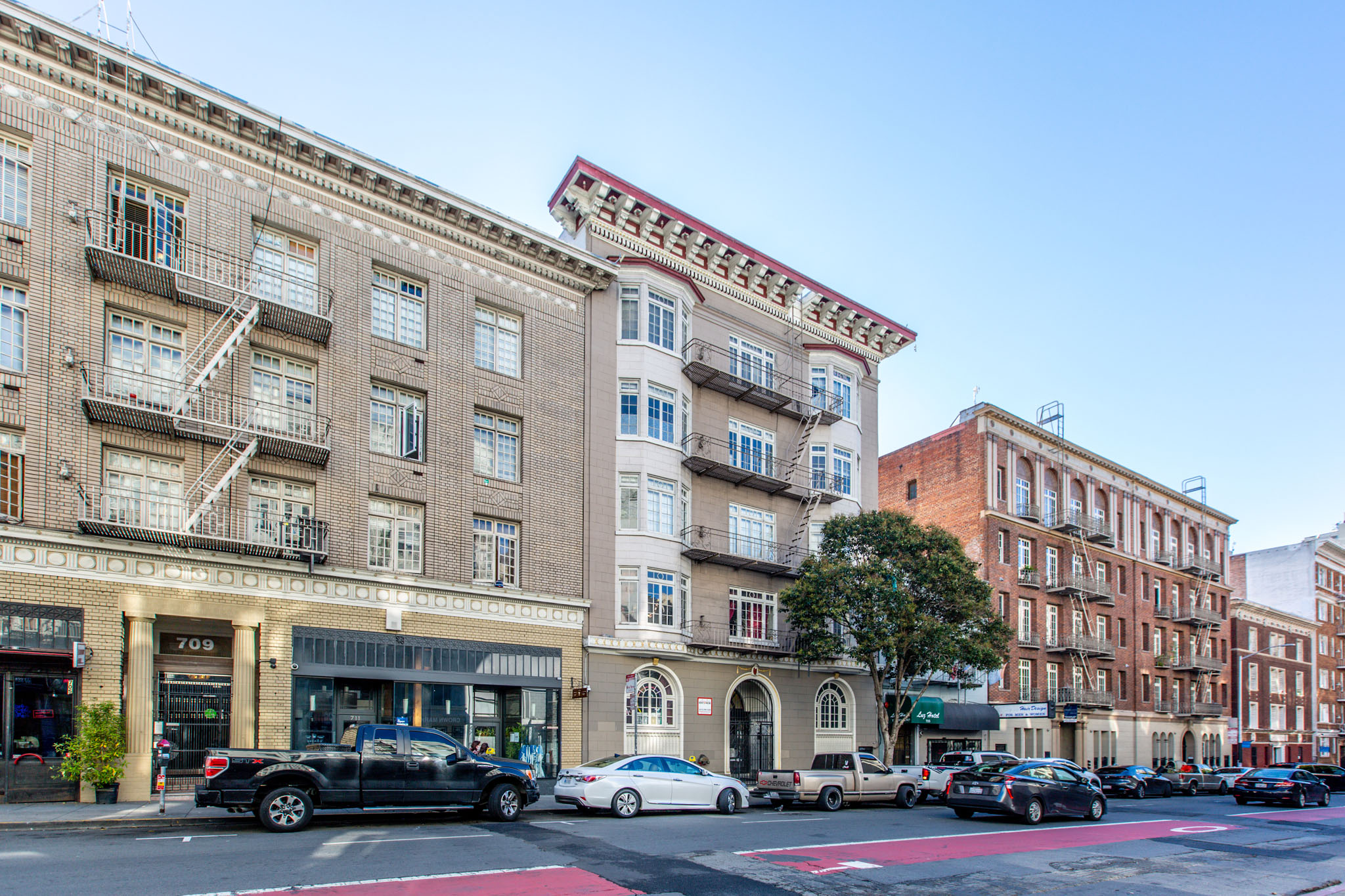 A street view of a city with cars parked on the side of the road.