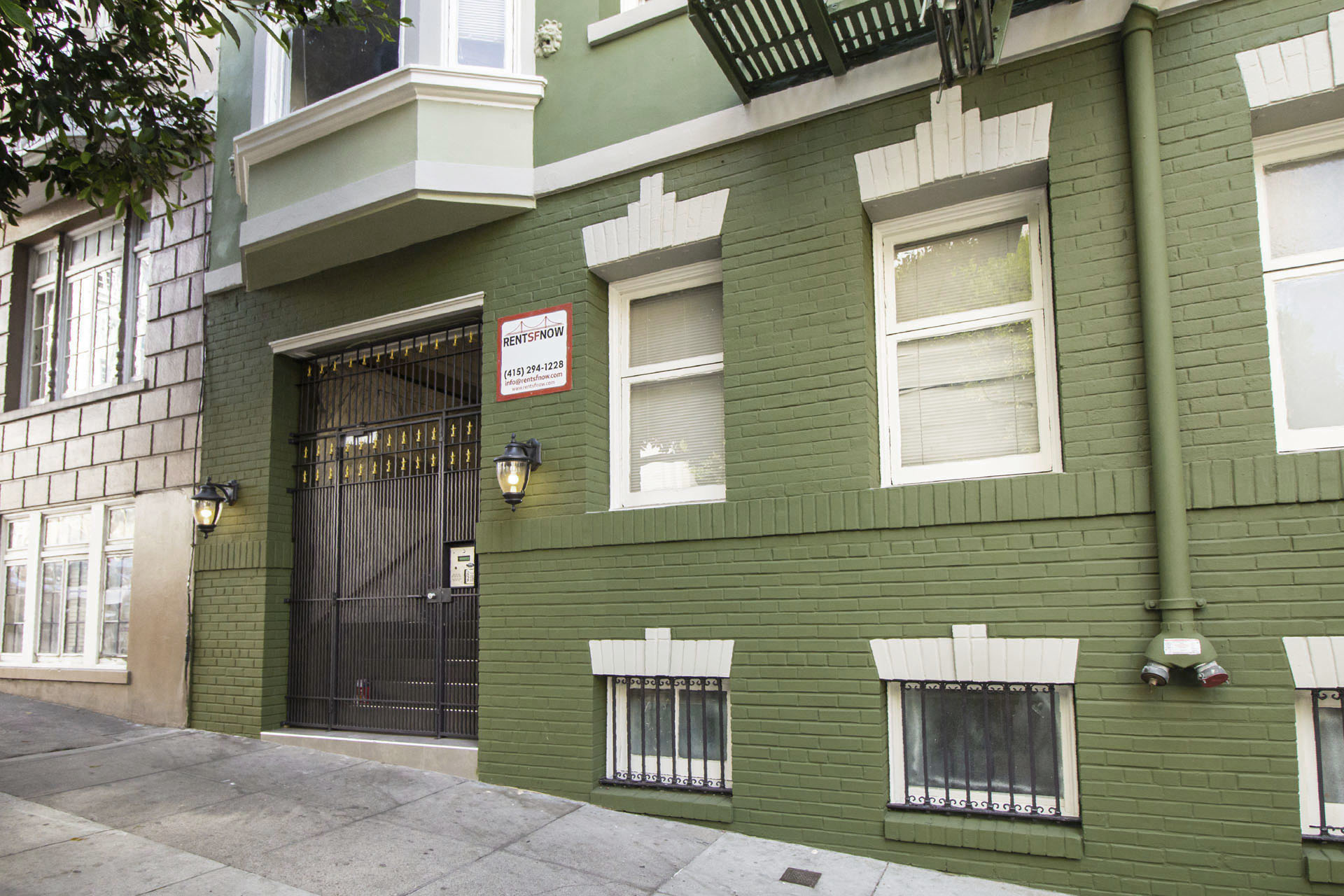 A green building with a black gate and a sign that says "Residential".