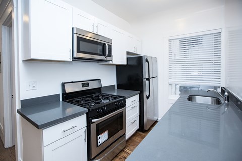 a kitchen with a stove and a refrigerator and a sink