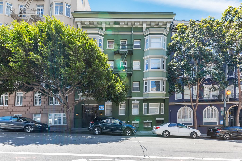 a green and white apartment building on a city street
