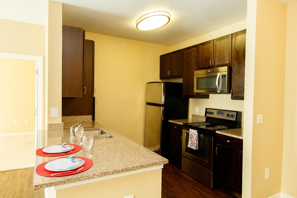 a kitchen with black appliances and a granite counter top