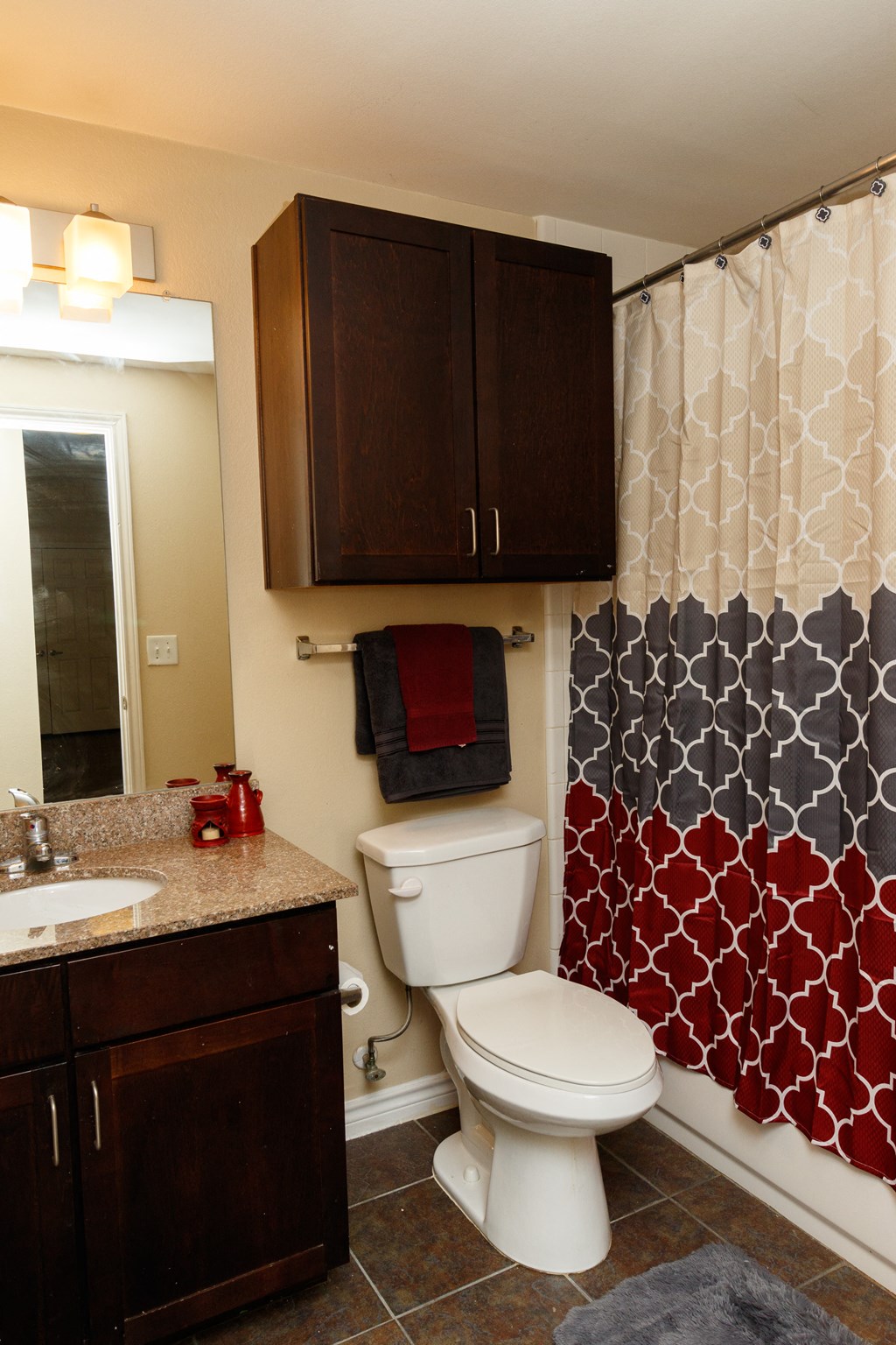 a bathroom with a toilet and a shower with a black and white shower curtain