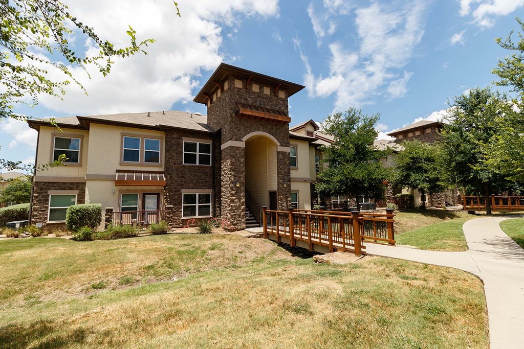 the front of a house with a wooden deck