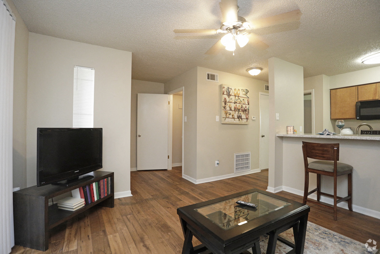 an open living room with a television and a kitchen
