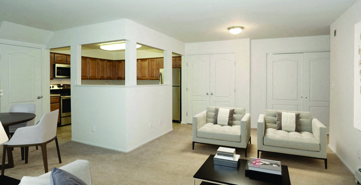a living room with couches and a table and a kitchen