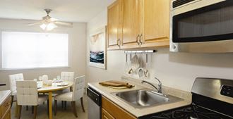 Galley Kitchen with Tables and Chairs at Pinewood Village, Coram, NY - Photo Gallery 4