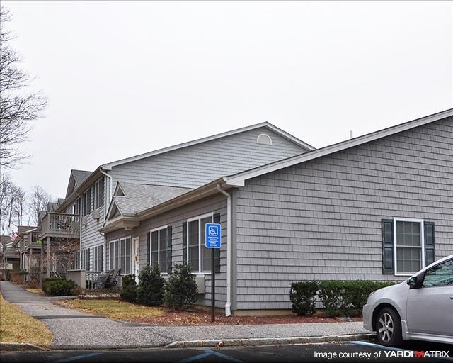 A grey building with a blue sign on the front door.