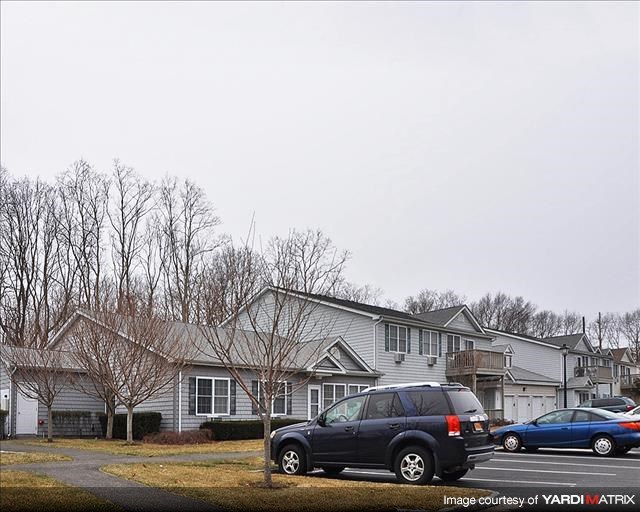 A residential area with houses and parked cars.
