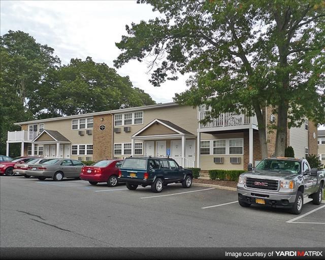 A parking lot with cars and a building in the background.
